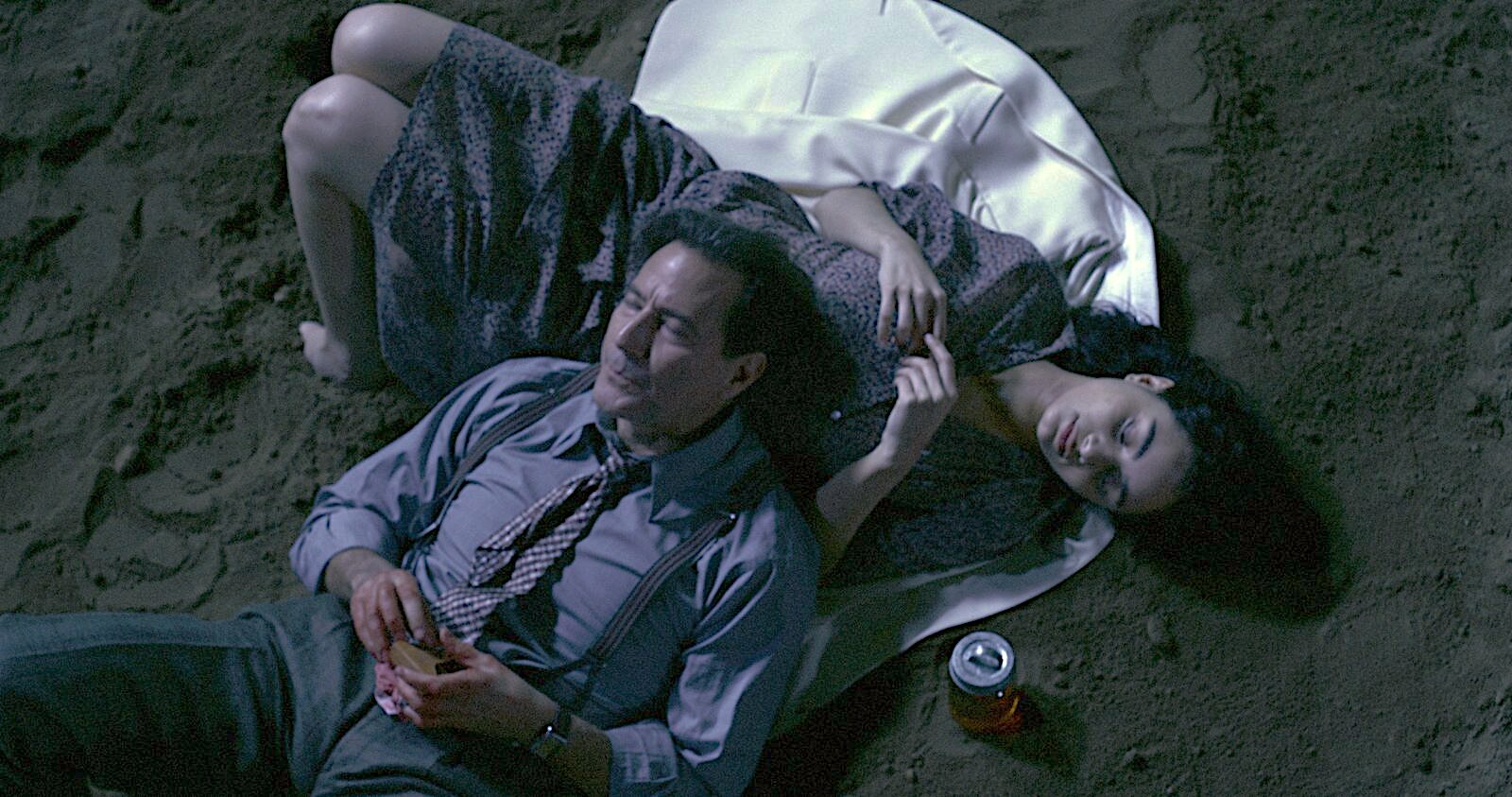 Henry Ian Cusick and Daniela Couso lying on the ground in a scene from Los Vampires
